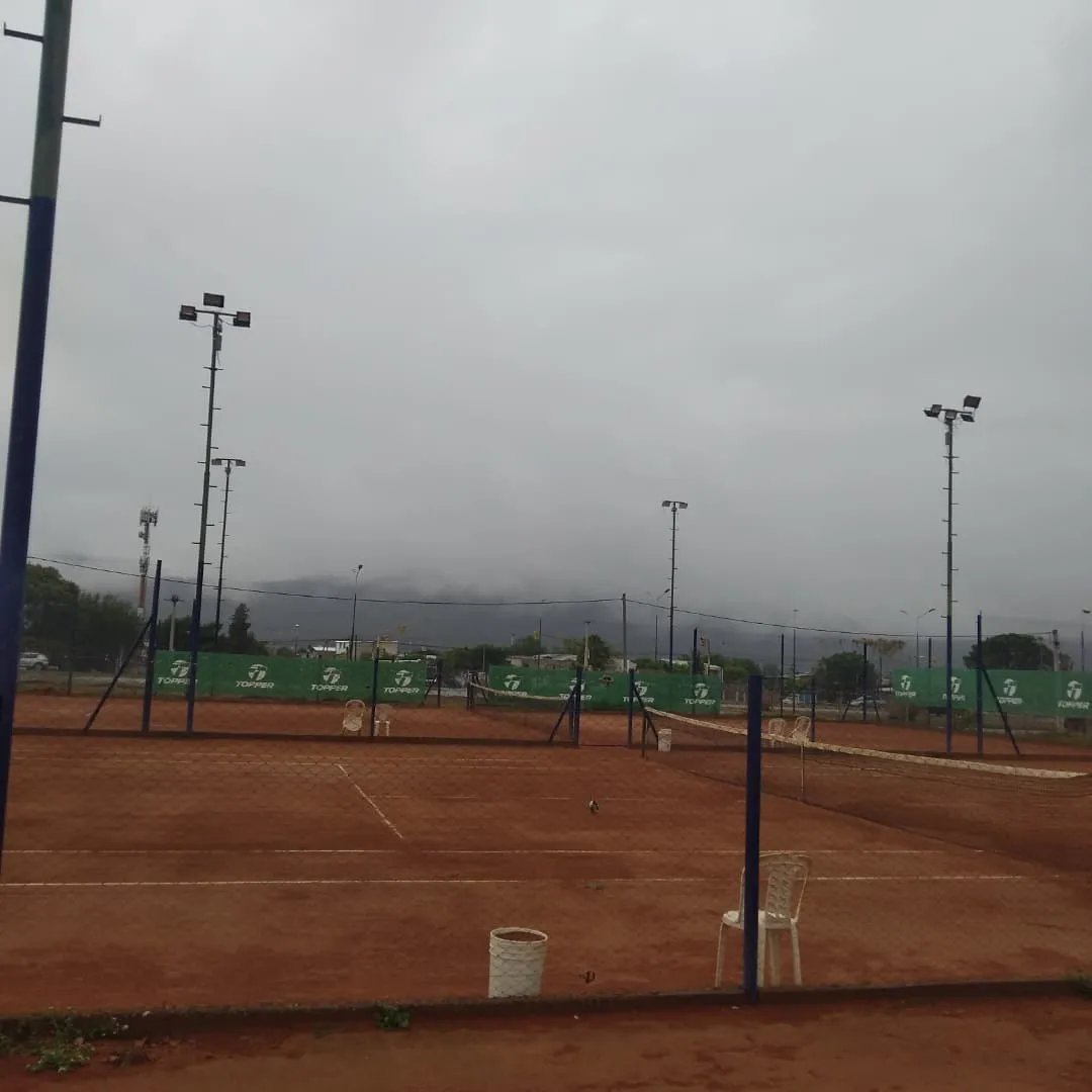 Vista panorámica de las canchas de polvo de ladrillo de Portal Tenis con el Cerro San Bernardo al fondo