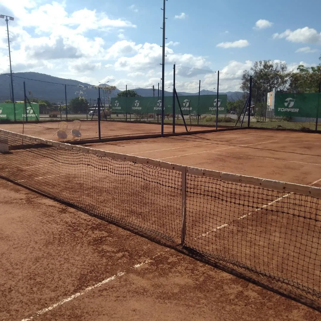 Cancha de tenis de Portal Tenis en un día soleado, con montañas y cielo de Salta