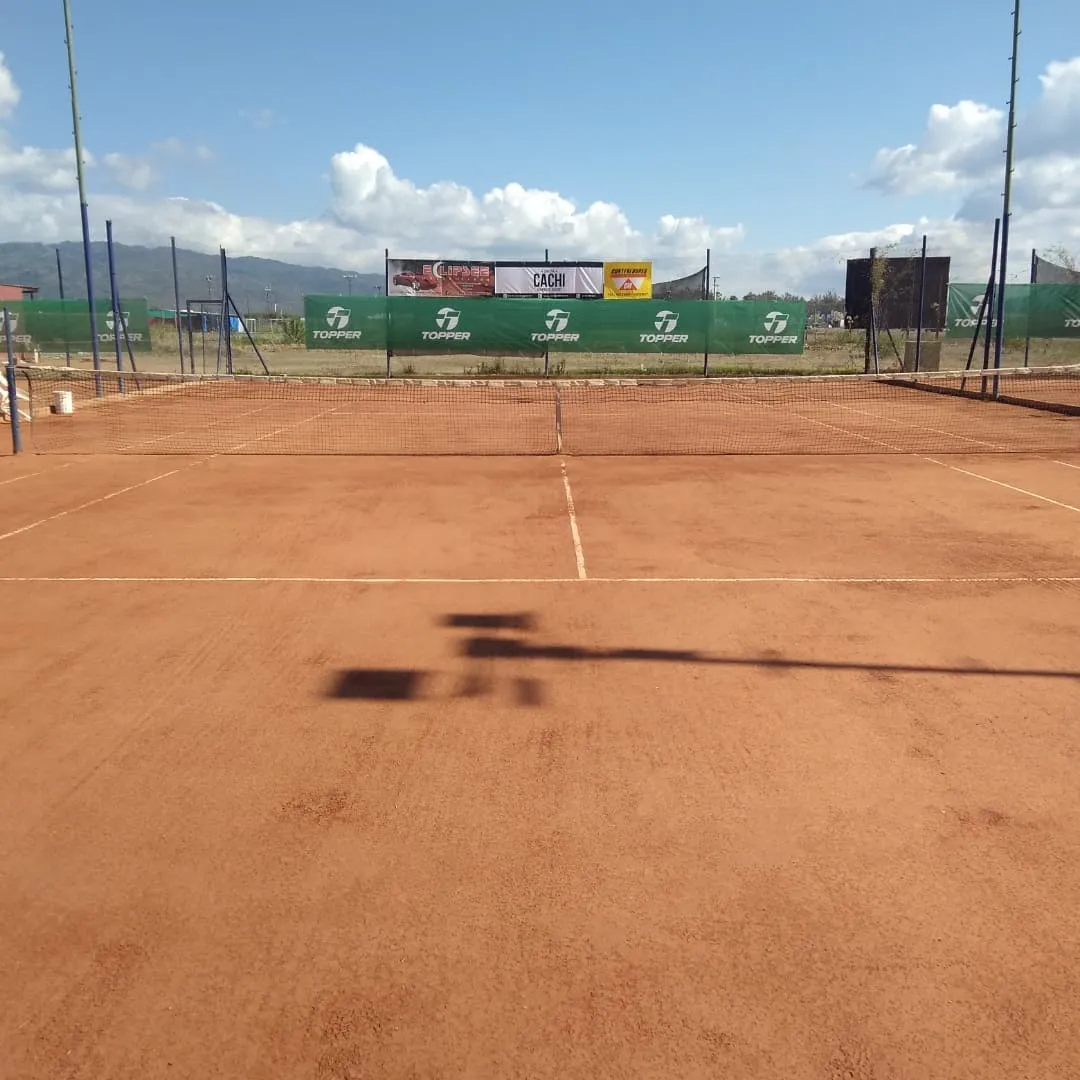 Cancha de polvo de ladrillo en Portal Tenis, Aeroclub Salta, con montañas de fondo